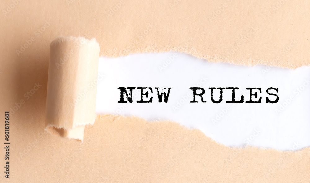 Poster the text new rules appears on torn paper on white background.
