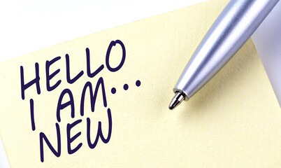 Sticky Note Message HELLO I AM NEW with pen on the white background