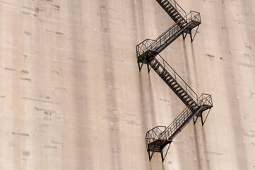 old, precarious emergency staircase on the exterior of a concrete structure