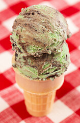Mint Chocolate Chip Ice Cream Cone on a Red and White Table