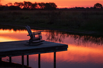 Sunset Over a Lake in Texas with an Empty Double Rocking Chair