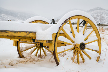 An Old Yellow Wagon Sits Under a Fresh Snow in the Colorado Mountains