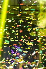 Thousands of confetti shot on air during a night festival. Ideal image for backgrounds. Multicolor are the confetti in the photo. The sky as a background is black.