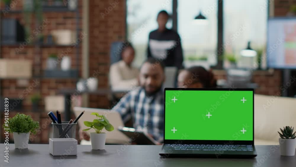 Poster office desk with green screen on laptop computer in workplace, mockup template with isolated chroma 