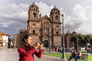 Tourist taking a picture in the main square of Cuzco.