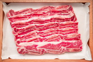 Cross Cut Short Ribs beef on wooden plate, Beef Short Ribs (Sliced) on wooden background.