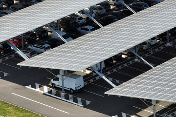 Aerial view of solar panels installed as shade roof over parking lot with parked cars for effective...