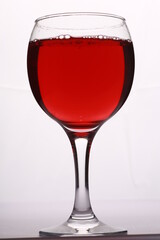 a glass with a red wine on a white background