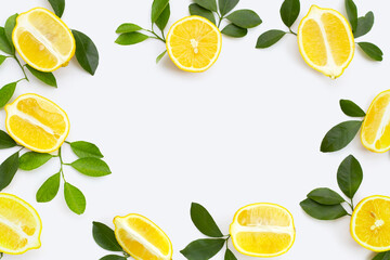 Frame made of lemon with green leaves on white background.