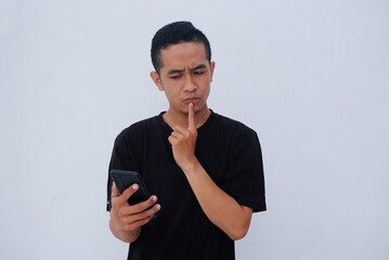 portrait asian guy with confusion gesture while holding phone