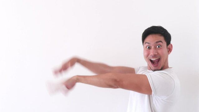 Happy asian man with his weird funny dance on white background.