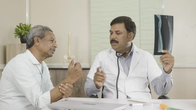 doctor explaining by seeing x-ray report to senior elderly patient at hospital - concep tof medical treatment, assistance and Healthcare