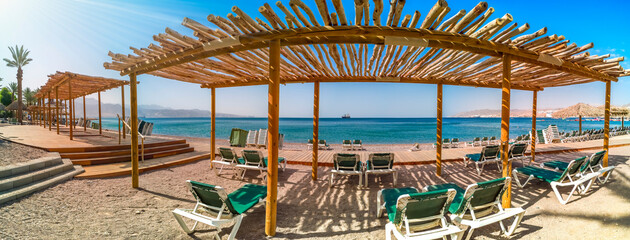 Naklejka na ściany i meble Morning panorama with tourist rest area on public beach of the Red Sea, Middle East. Concept of happy and bliss vacation