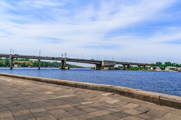 Fototapeta premium View from Flotsky boulevard to Inhulskyy bridge in Mykolaiv, Ukraine. Embankment of the Inhul river in the Ukrainian city