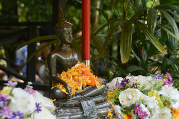 Sprinkle water onto a Buddha Statue.