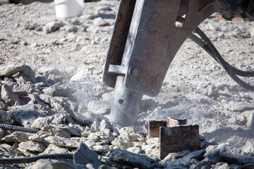 Jackhammer machine breaks concrete in the city.