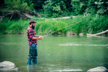 Man pulling fishing rod. Fisherman man on river or lake with fishing rod.
