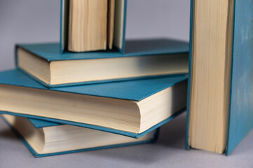 A few books in blue cover against a gray background. A group of hardcover books. Close-up.