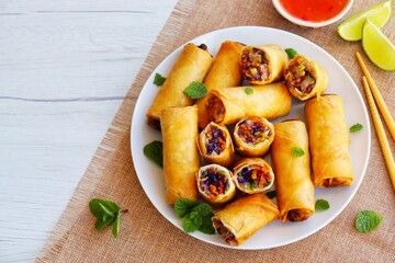 Crispy vegetarian spring rolls on plate with white wood table background.Top view.Copy space