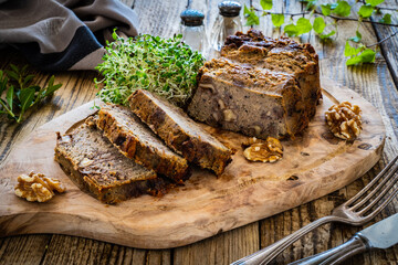 Tasty pate with walnuts on cutting board