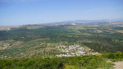 Obraz premium A view near a Deir Al-Mukhraqa Carmelite Monastery on the adjacent valley with roads, settlements and fields in northern Israel