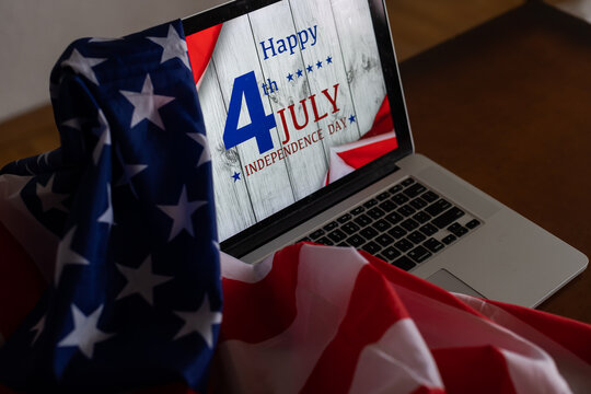 American flags with inscription Happy Independence Day on laptop