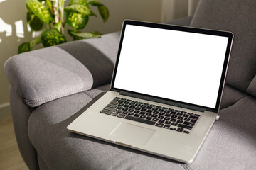 Blank screen laptop computer on sofa