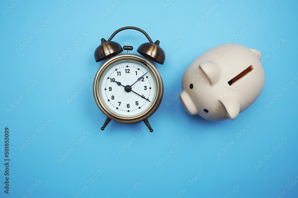 Poster piggy bank and alarm clock with space copy on blue background