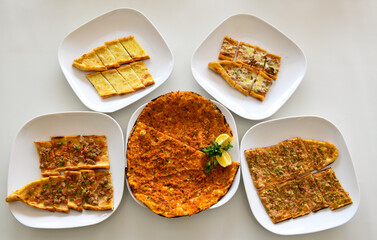 Top view of table scene with assorted take out or delivery foods. Meat and chicken doner kebab sandwich, wrap and on the plate with vegetables and sauce, including fries and pickles.