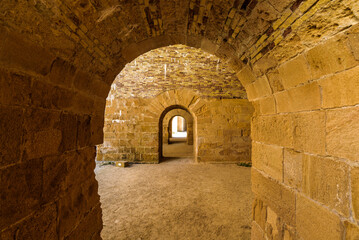 Obraz premium View of stone roman arches linking rooms inside the Maniace Castle in the island of Ortigia, built during the Swabian period by Emperor Frederick II of Swabia.