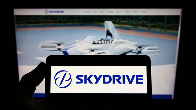 Stuttgart, Germany - 03-29-2022: Person holding smartphone with logo of Japanese aviation company SkyDrive Inc. on screen in front of website. Focus on phone display.