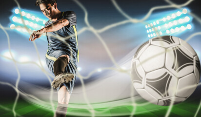 Professional football or soccer player in action on stadium with flashlights, kicking ball for...