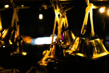 Golden bells hanging on a railing with small lightings - Powered by Adobe