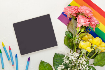 Roses on a rainbow flag and chalkboard with chalks