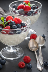 Sweet and homemade Panna Cotta with blueberries and raspberries jam.