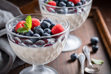Traditional and sweet Panna Cotta with blueberries and raspberries jam.