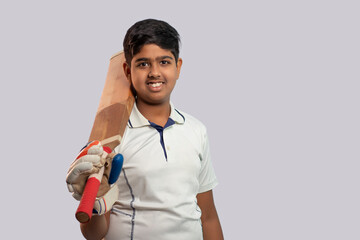 A boy in cricket uniform holding Cricket Bat