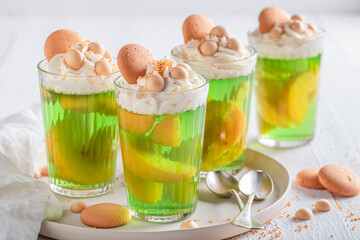 Sweet green jelly with whipped cream and nectarines .