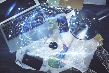 Social network hologram drawings over computer on the desktop background. Top view. Double exposure.