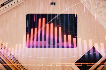 Double exposure of forex graph hologram over desktop with phone. Top view. Mobile trade platform concept.