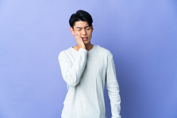 Young Chinese man isolated on purple background with toothache