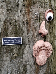 Alter Baum mit Gesicht sowie Tafel und Sinnspruch am Biergarten einer Gastwirtschaft in der...