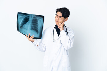 Young Chinese doctor man holding radiography isolated on white background having doubts and thinking