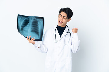 Young Chinese doctor man holding radiography isolated on white background celebrating a victory