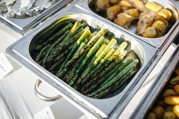 Grilled green asparagus in a silver tray at a barbecue buffet