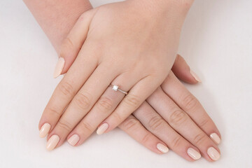 Fototapeta na wymiar Golden Ring on a female hand, diamonds Diamond ring in hands of young lady. Close-up photo shoot