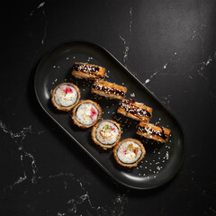 Tempura Ebi. Hot fried sushi rolls and maki with shrimp on black stone