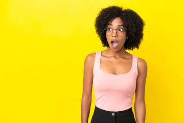 Young African American woman isolated on yellow background doing surprise gesture while looking to the side