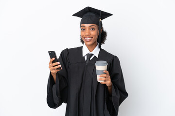 Young university graduate African American woman isolated on white background holding coffee to take away and a mobile