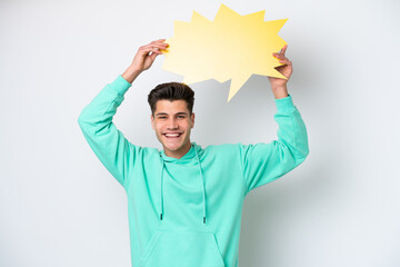 Young handsome caucasian man isolated on white bakcground holding an empty speech bubble
